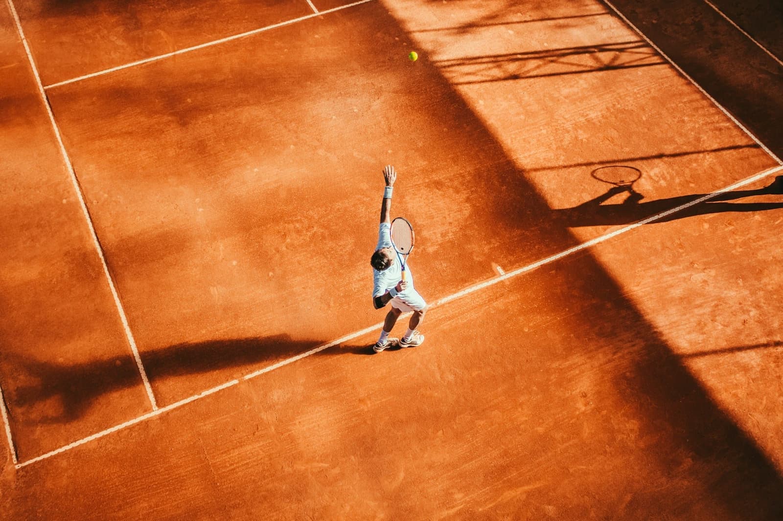 Tennisser op een gravelbaan, van boven gezien