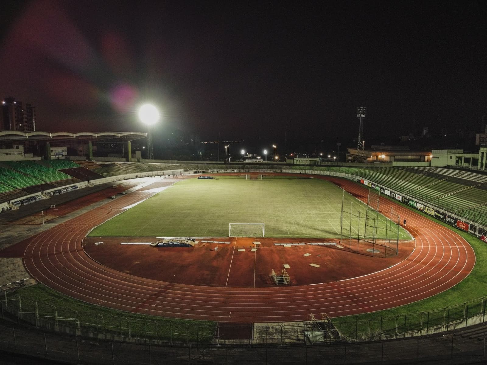 Stadion met atletiekbaan rond een voetbalveld bij avond